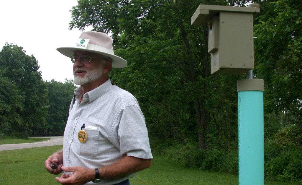 Dick stands next to a nest box at a forest edge