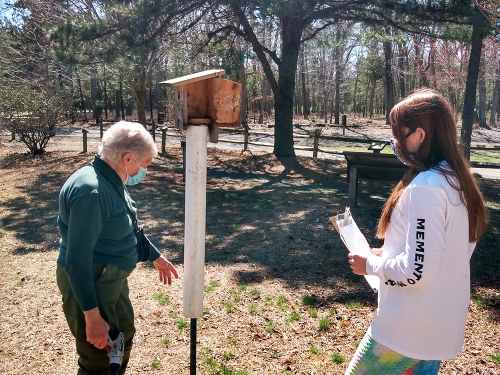 two people monitor a nest